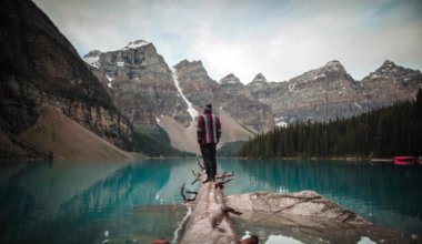 A solo traveler standing on a log in Alberta, Canada