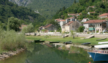 A small village surrounded by trees on the banks of a river in Montenegro