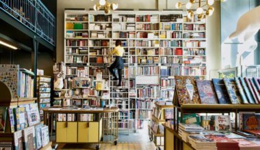 A woman in a bookstore looking at books on a ladder