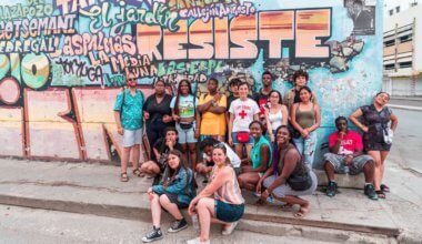 Students from FLYTE on a trip abroad posing near street art
