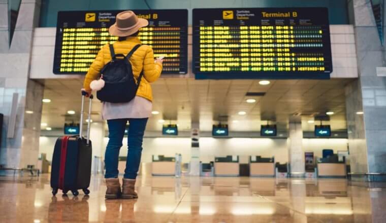 woman standing in front of flight departure board at Barcelona airport