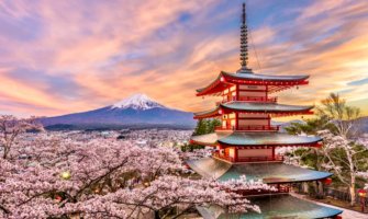 A towering, colorful pagoda in the foreground with beautiful Mount Fuji in the distance in Japan