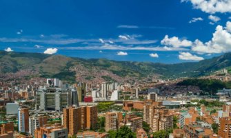 The skyline of colorful Medellin, Colombia surrounded by greenery on a sunny day