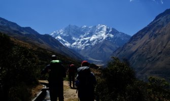 Three travelers hiking the Salkantay trek in Peru on a guided tour