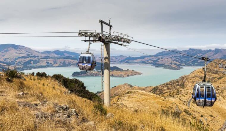 Gondolas with panoramic views of mountains and a large inlet in the background, in Christchurch, New Zealand