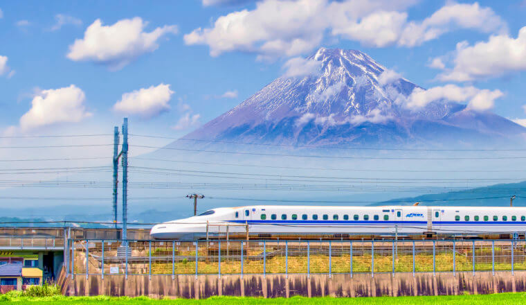A bullet train crosses in front of the famous Mount Fuji in the background in Japan
