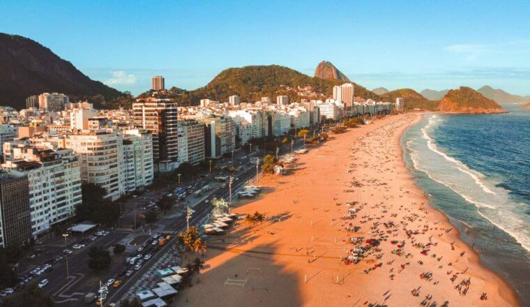 Long stretch of beach lined with multistory buildings in Rio de Janeiro, Brazil