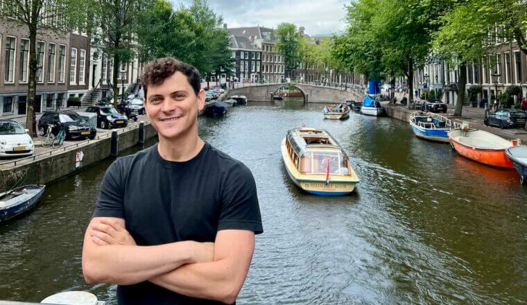 Nomadic Matt posing near the canal in Amsterdam