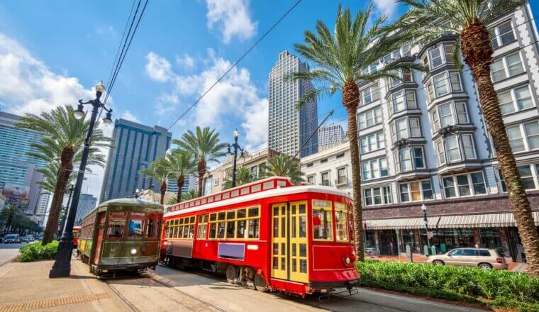 A bright red streetcar driving around sunny New Orleans, USA