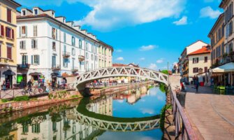 A beautiful bridge across a narrow canal in sunny Milan, Italy
