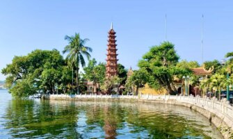 A sunny day near the lake in Hanoi, with a tall, historic pagoda in the background