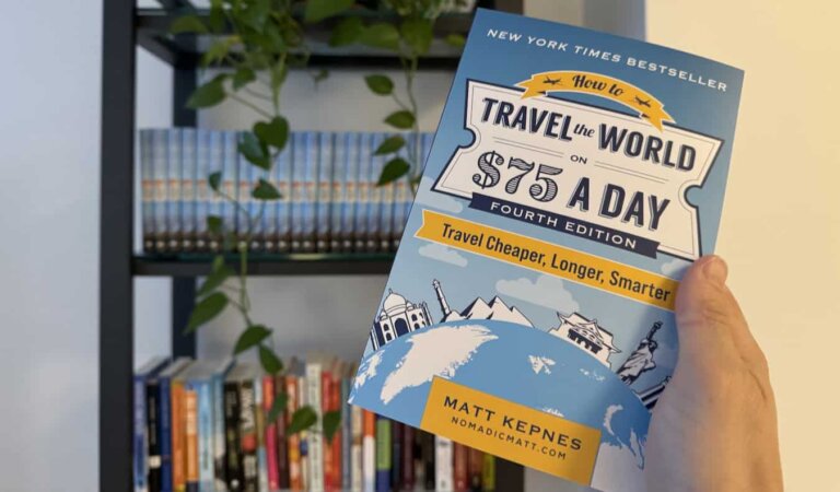 Nomadic Matt's new budget travel book in front of a book shelf