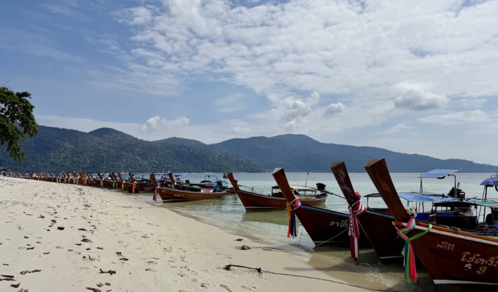 Lots of longtail boats on a beach in Thailand near the island of Ko Lipe